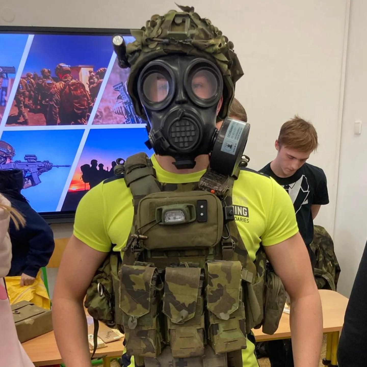 Žák v armádním ochranném obleku s plynovou maskou při ukázce chemických jednotek AČR.